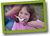 Campers eat a marshmallow Eating off a stick